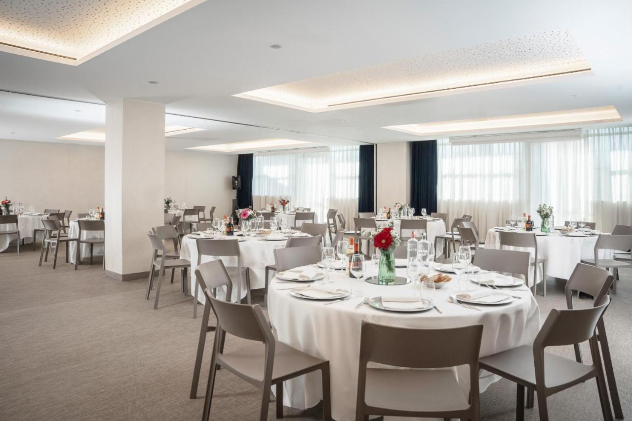 een feestzaal met witte tafels en stoelen bij Just Hotel Lomazzo Fiera in Lomazzo