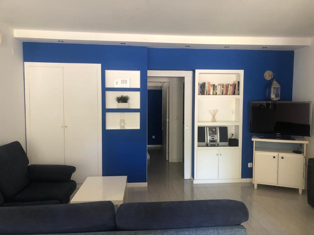 een woonkamer met een bank en een blauwe muur bij Troia in Troia +33 foto's