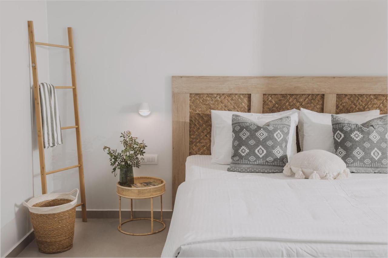 een slaapkamer met een groot wit bed met kussens bij Anassa Stalis Luxury Suites by Estia 'Adults Only' in Stalida