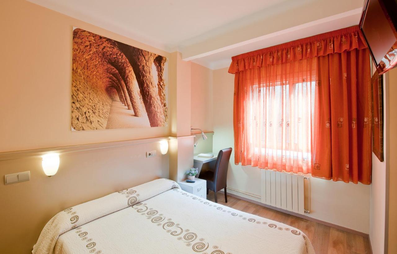 een slaapkamer met een bed en een rood raam bij Hostal Barcelona in Barcelona