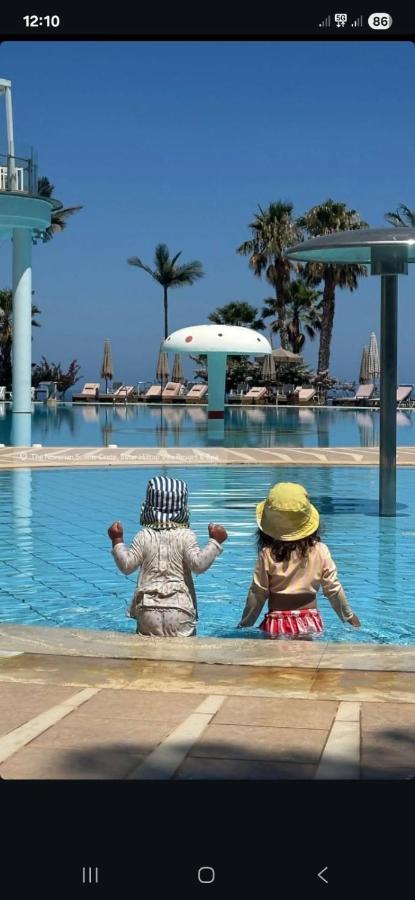 Twee mensen zitten in het water van een zwembad. bij The Noverian Scenic Crete 5 Star Hilltop Villa Resort & Spa in Mali