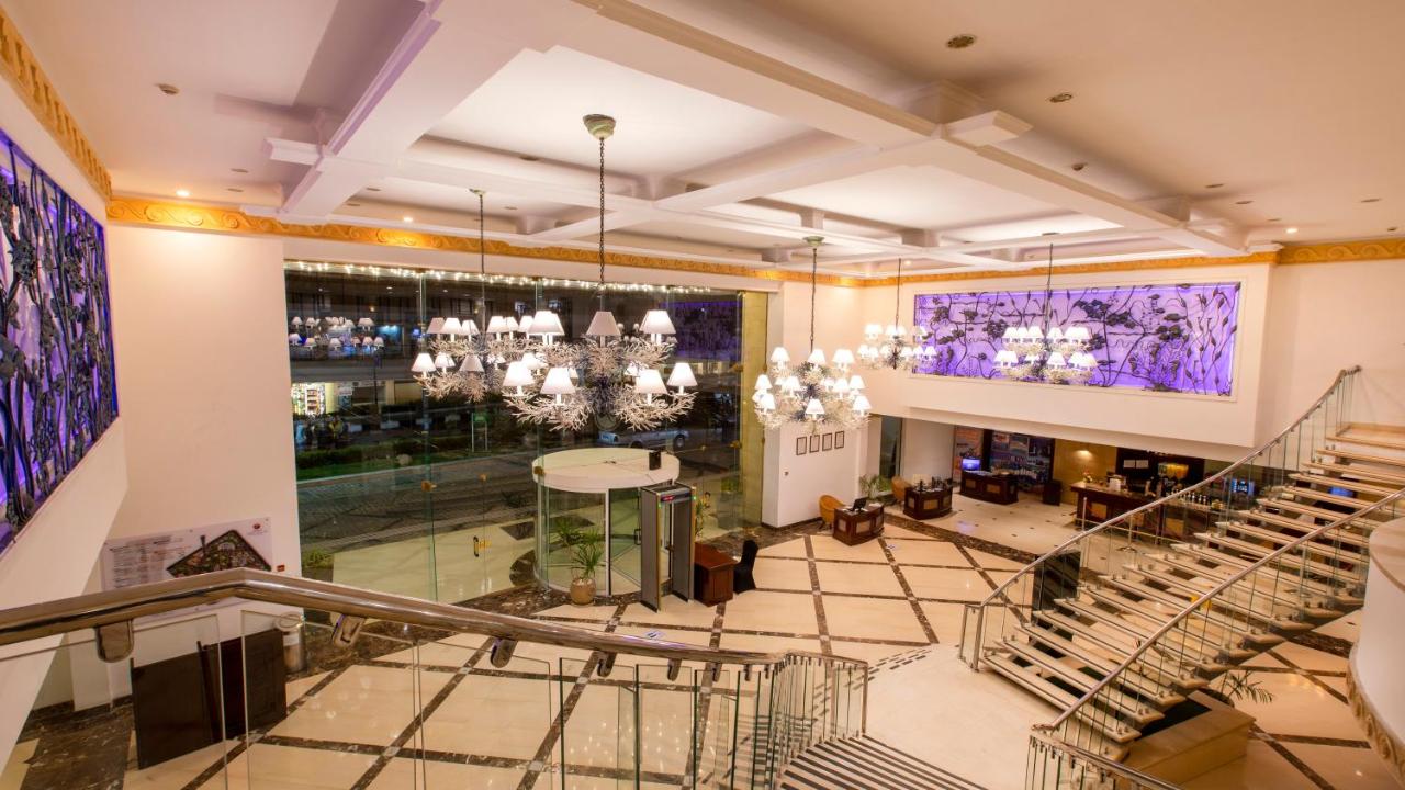 Een bovenaanzicht van een lobby met trappen en kroonluchters. bij Naama Bay Hotel & Resort in Sharm El Sheikh