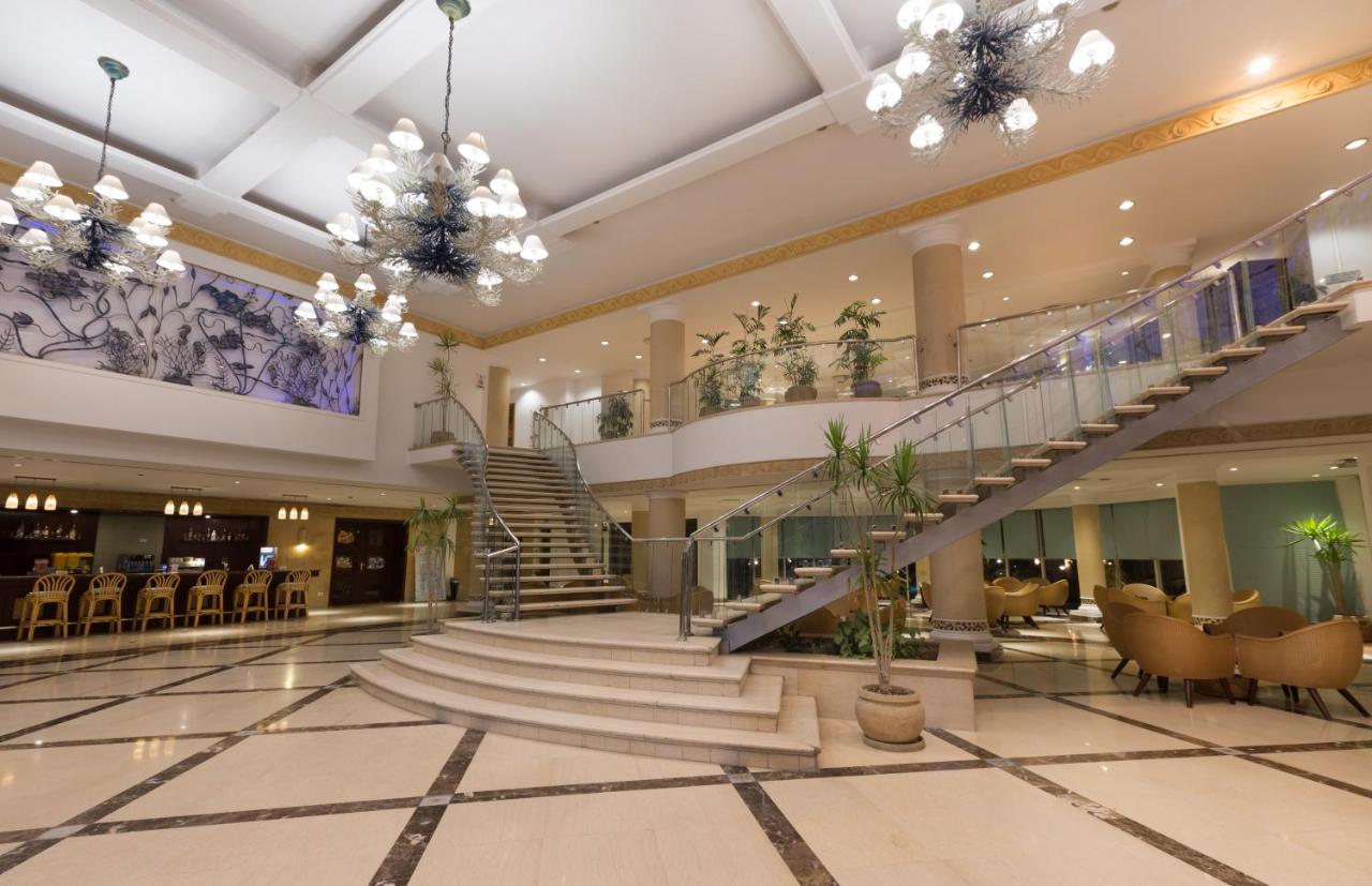 een grote lobby met een trap en stoelen bij Naama Bay Hotel & Resort in Sharm El Sheikh