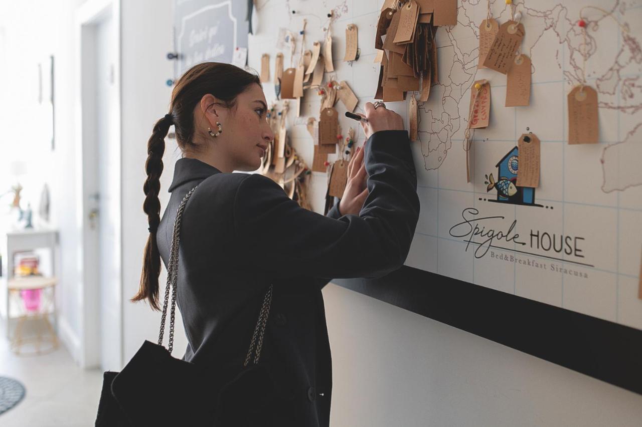 Een vrouw kijkt naar een muur in een winkel. bij B&b Spigolehouse in Siracusa