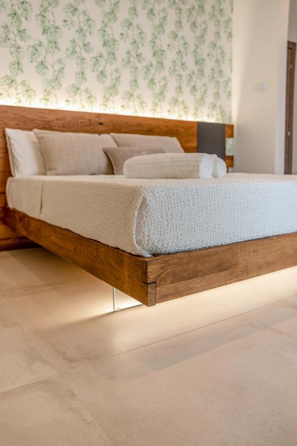 een bed met een houten frame in een kamer bij Sarmenti Agriresort in Otranto