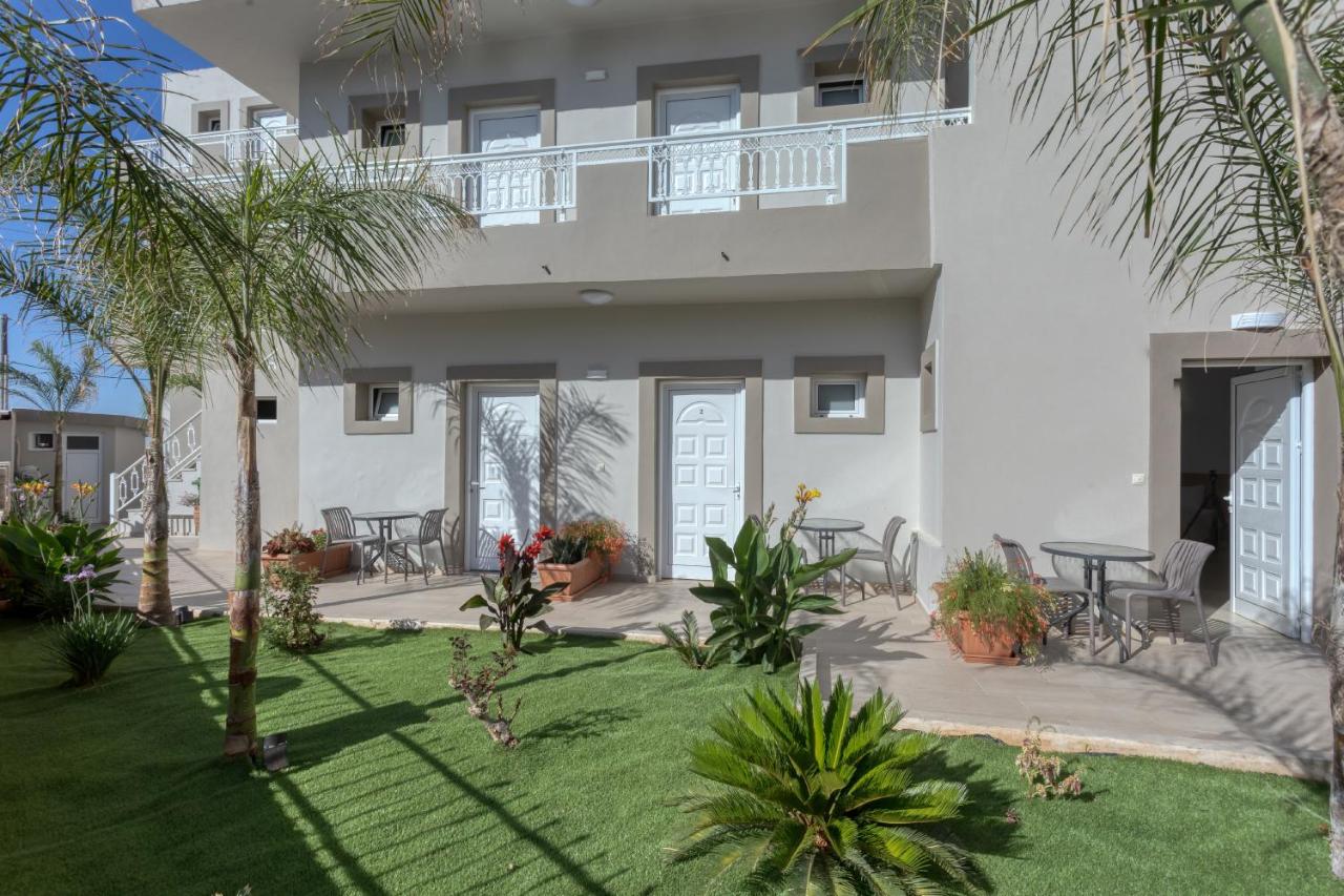een wit huis met een binnenplaats met palmbomen bij Amara Seaside by Estia in Malia