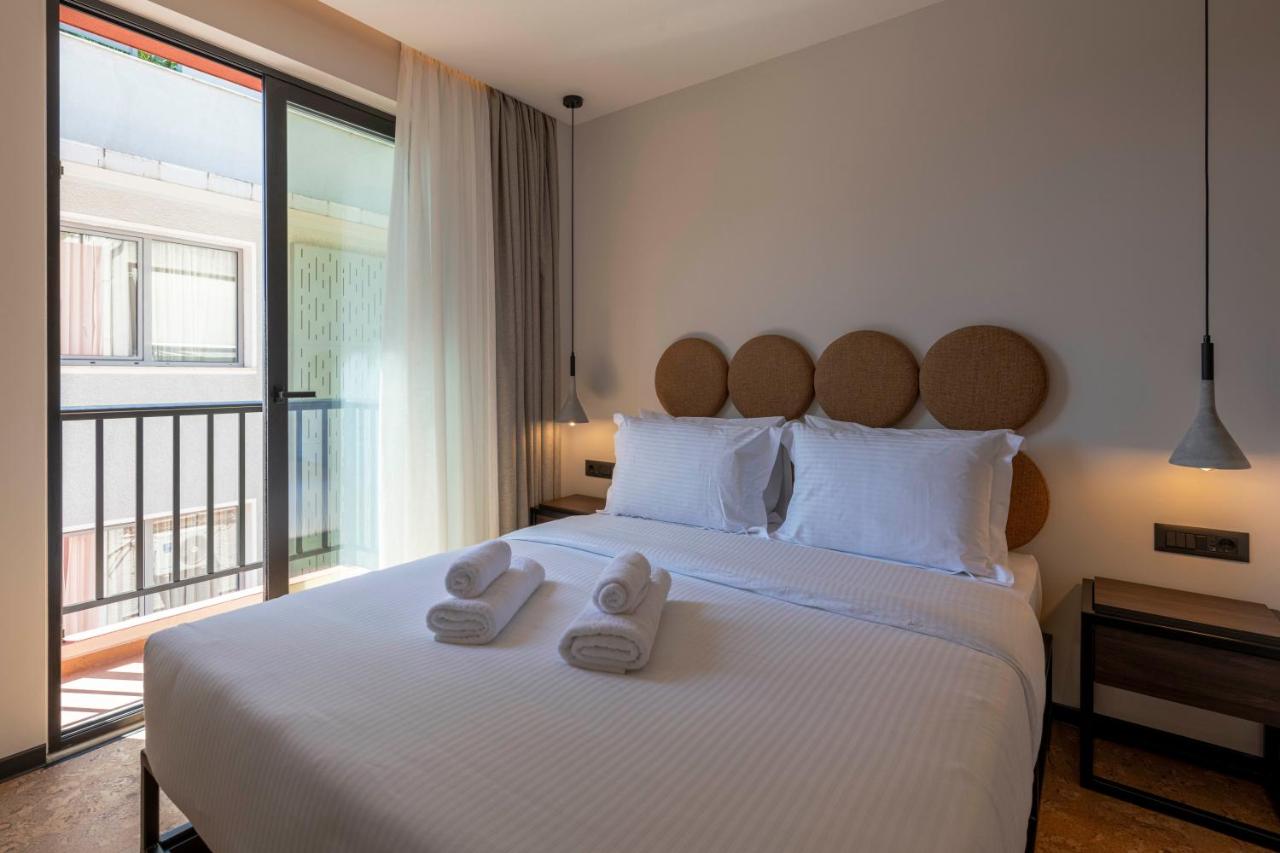 een slaapkamer met een groot wit bed met handdoeken erop bij PAREA Athens in Athene