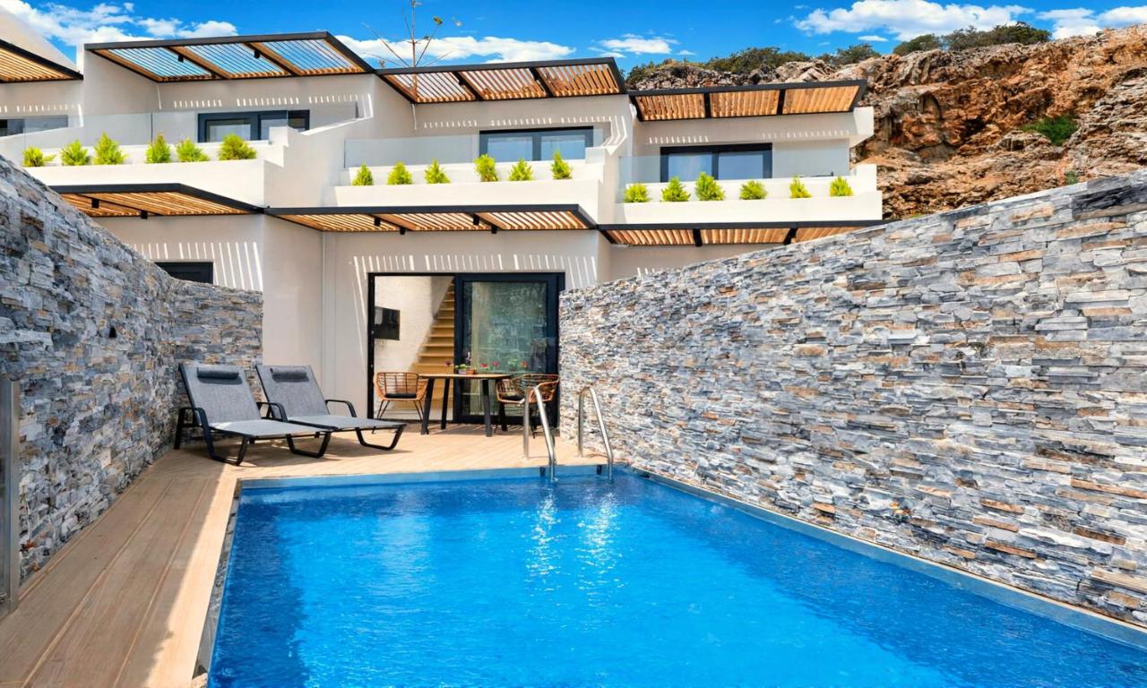 een villa met een zwembad voor een huis bij Aelia Suites in Agios Nikolaos