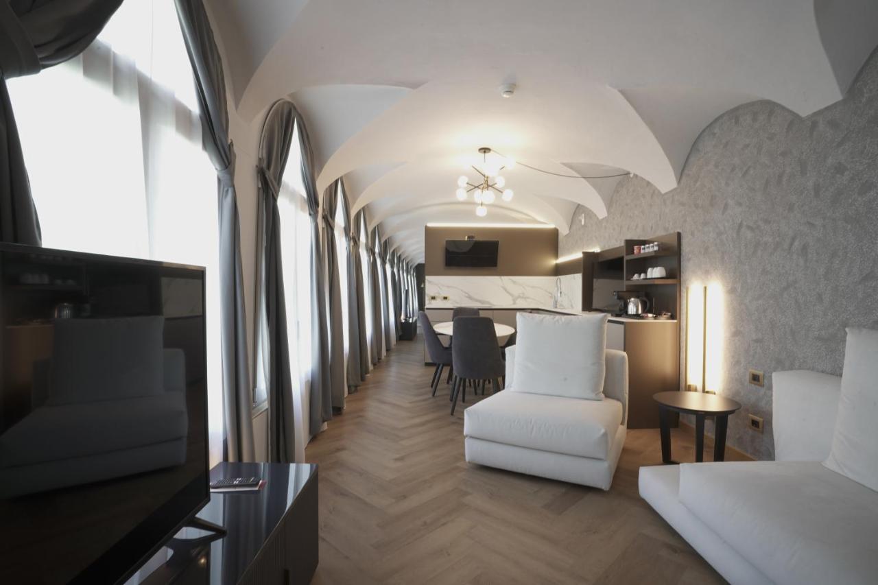 een woonkamer met een witte stoel en een tafel bij Palazzo Santo Spirito in Bergamo +100 foto's