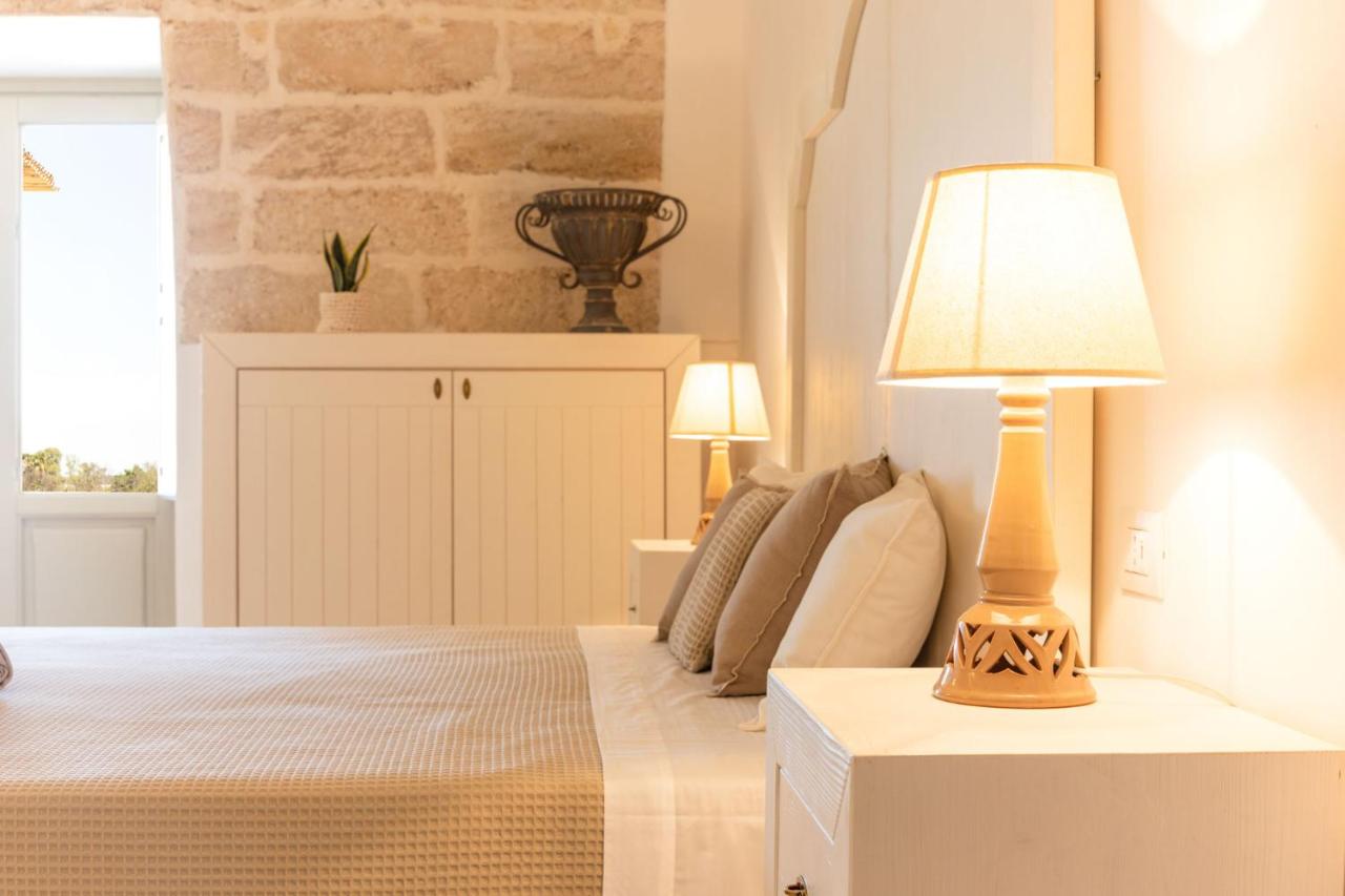 een slaapkamer met een bed en een lamp op een tafeltje bij Masseria Macchiaforte in Gallipoli