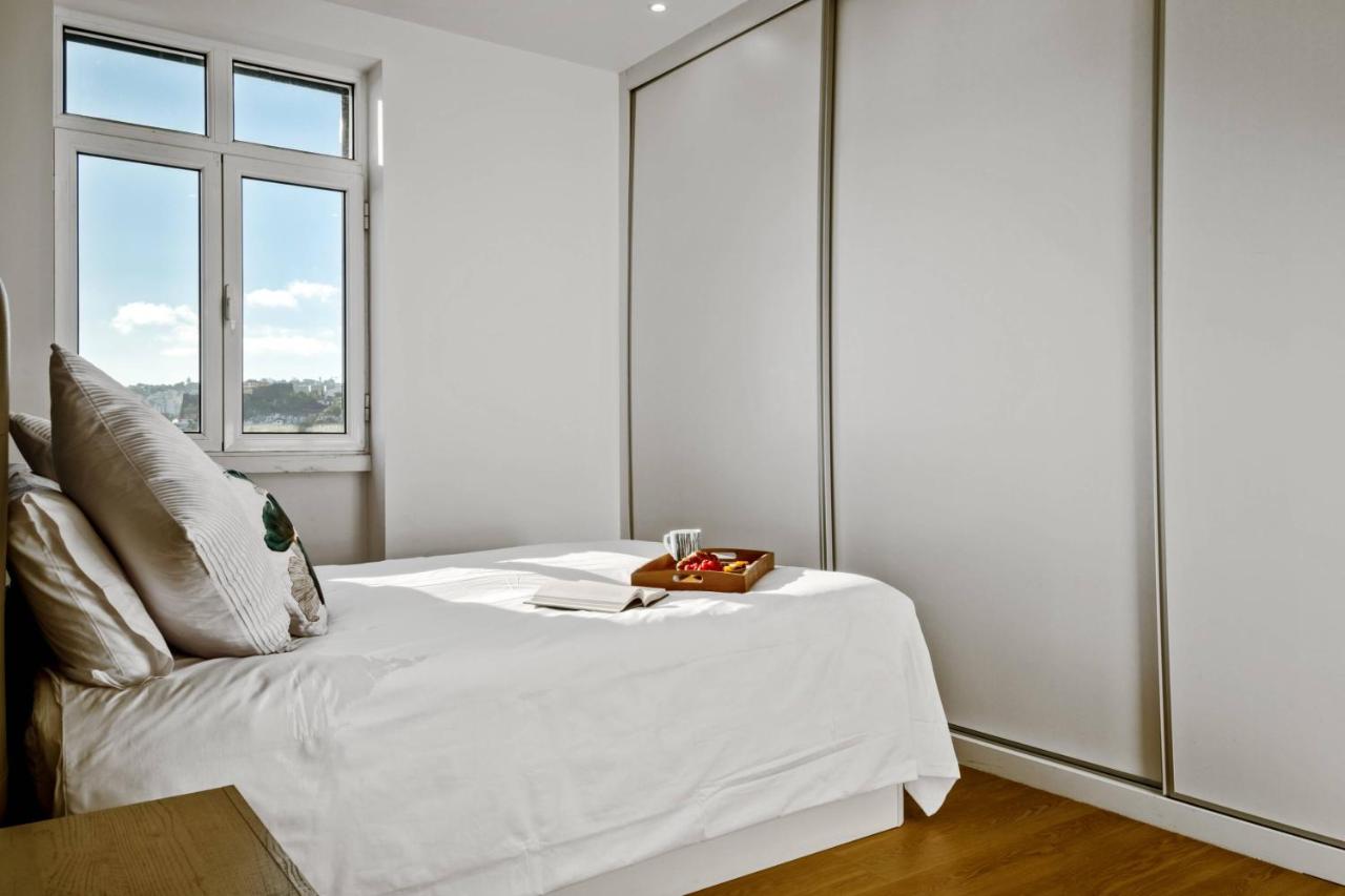 een witte slaapkamer met een bed met een raam bij Apartamento Eden in Funchal
