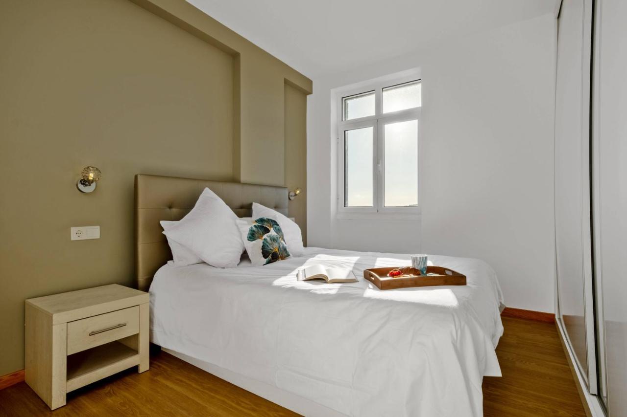 een slaapkamer met een wit bed met een dienblad erop bij Apartamento Eden in Funchal