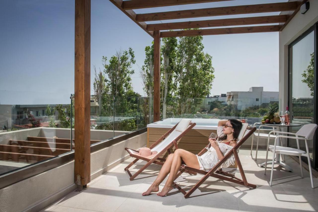 een vrouw die op een stoel op een balkon zit bij VAYA Suites by Omilos Hotels in Amoudara Herakliou