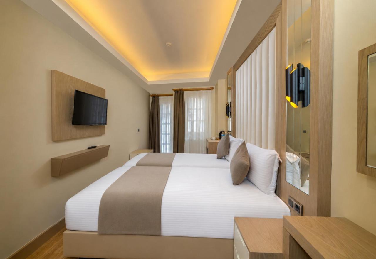 een hotelkamer met een bed en een televisie bij Asilzade Hotel Sirkeci in Istanbul