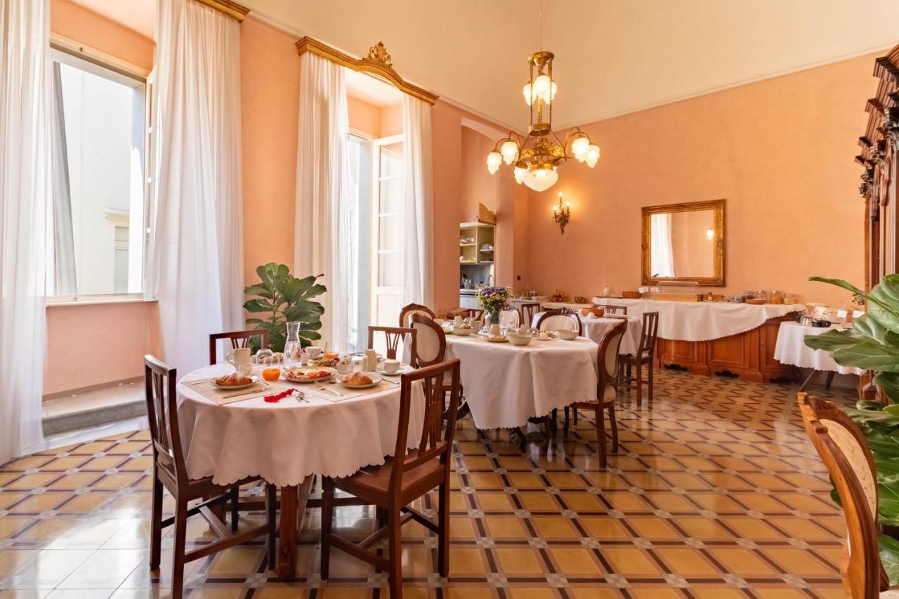 een eetkamer met tafels met witte tafelkleden bij Palazzo Zacà in Gallipoli