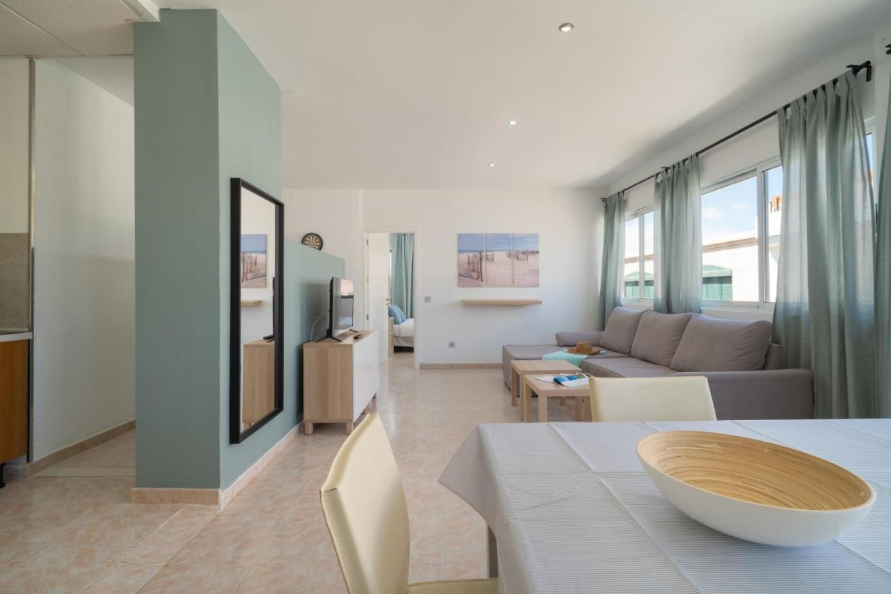 een woonkamer met een bank en een tafel bij Sabbia Suites Arrecifeando in Arrecife