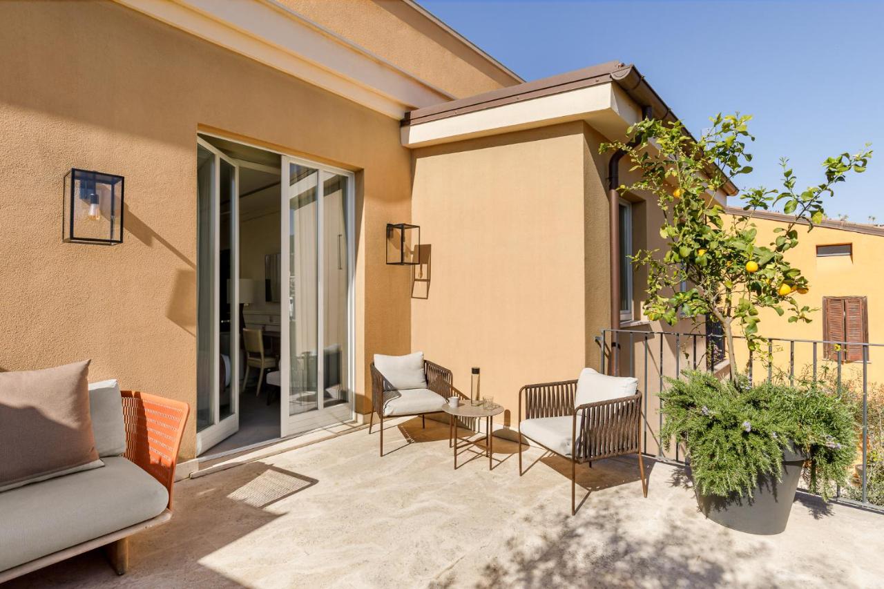 een terras met een bank en stoelen op een balkon bij Room Mate Gran Filippo I, Rome-Fontana di Trevi in Rome