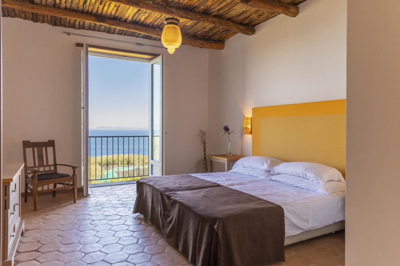 een slaapkamer met een groot bed en een groot raam bij Villa Puolo – With Private Sea Access in Sorrento