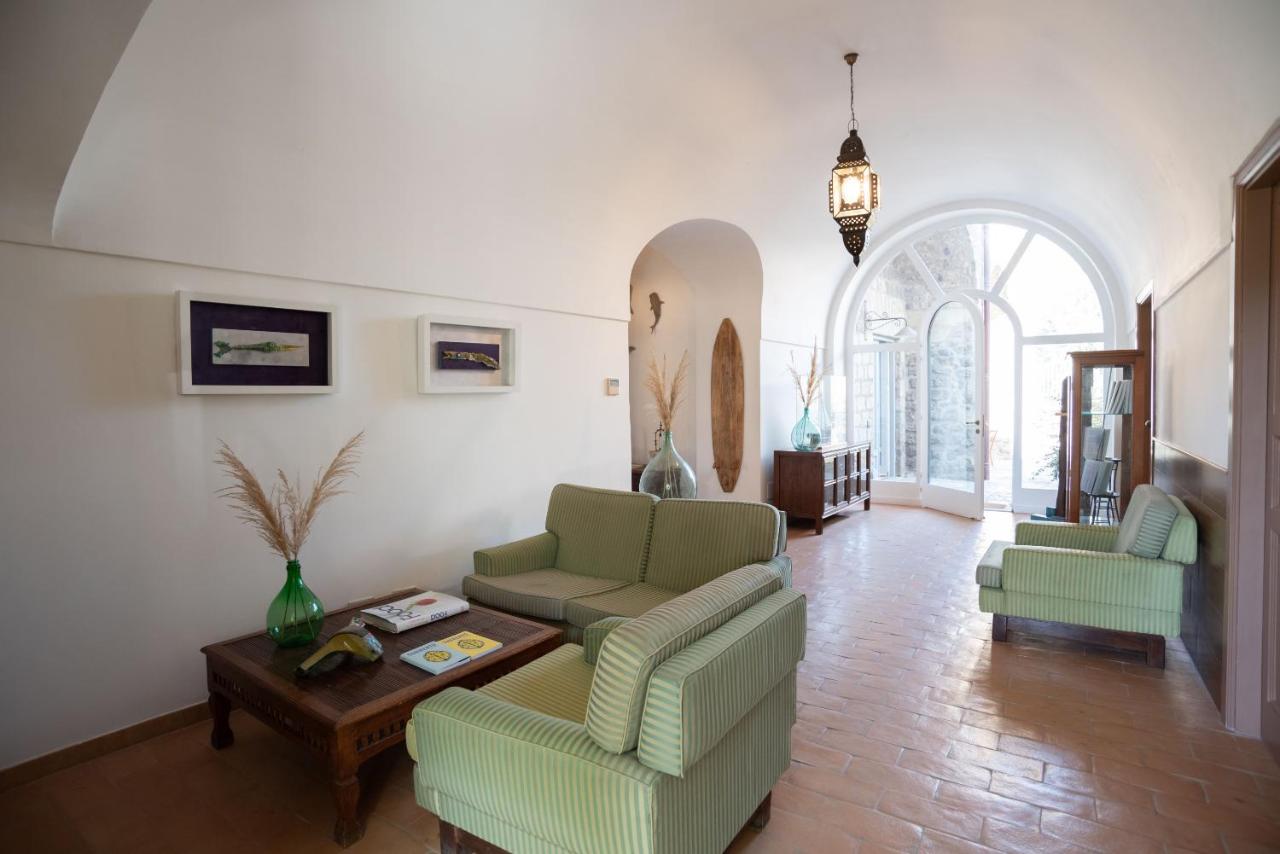 een woonkamer met twee banken en een tafel bij Villa Puolo – With Private Sea Access in Sorrento