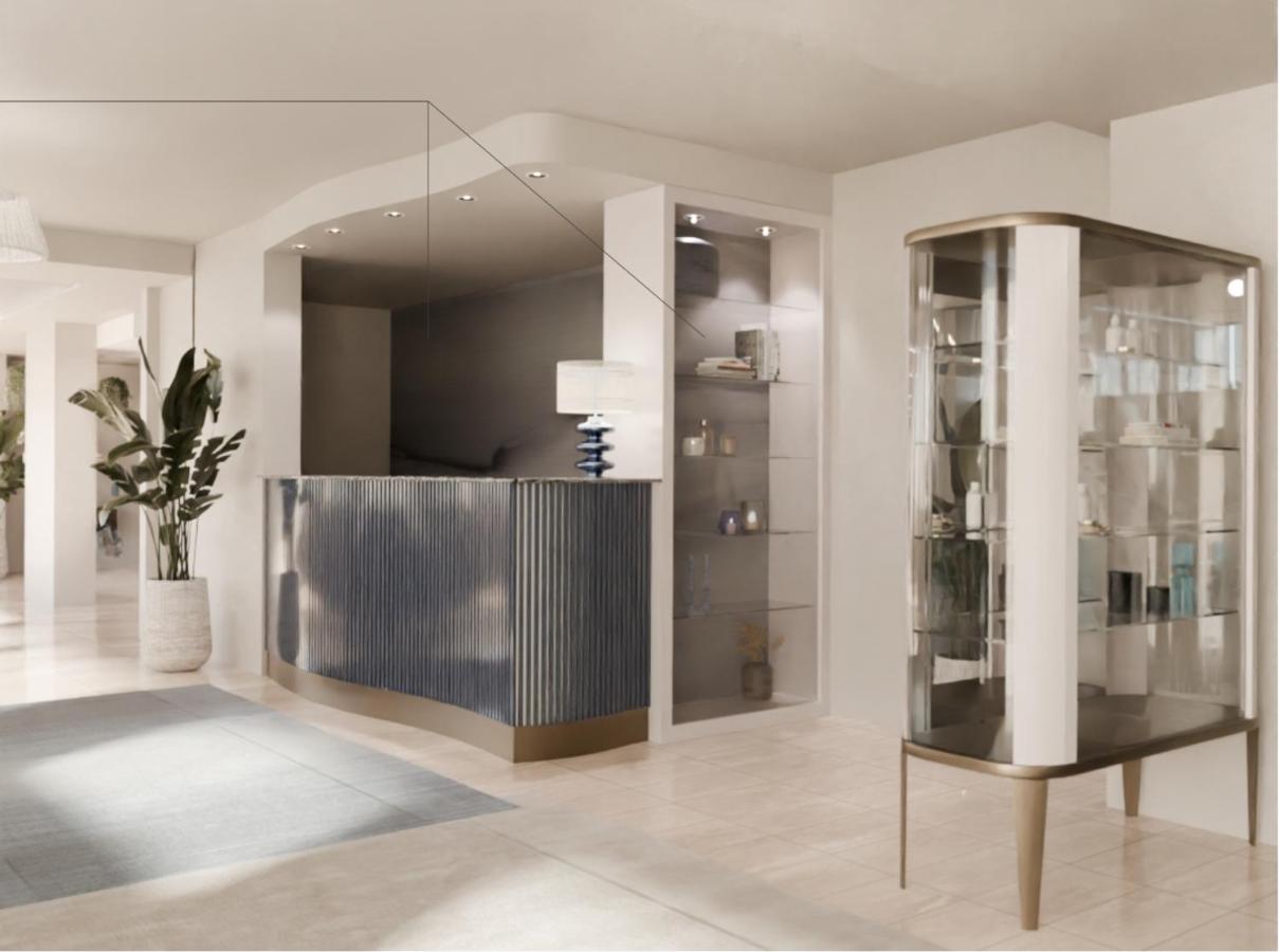 een woonkamer met een glazen vitrinekast en een tafel bij Baia del Mar Beach Boutique Hotel in Lido di Jesolo