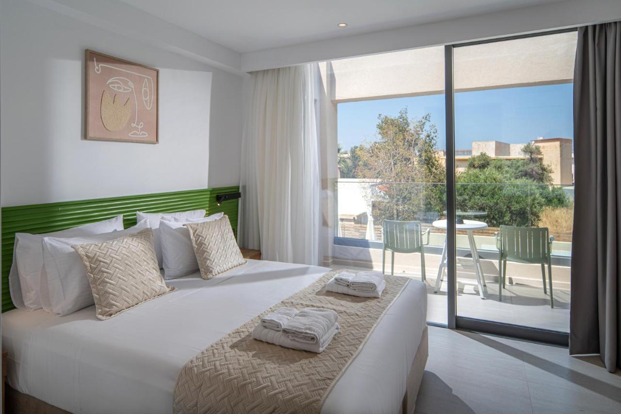 een slaapkamer met een groot bed en een balkon bij Meramaglia Hotel in Malia