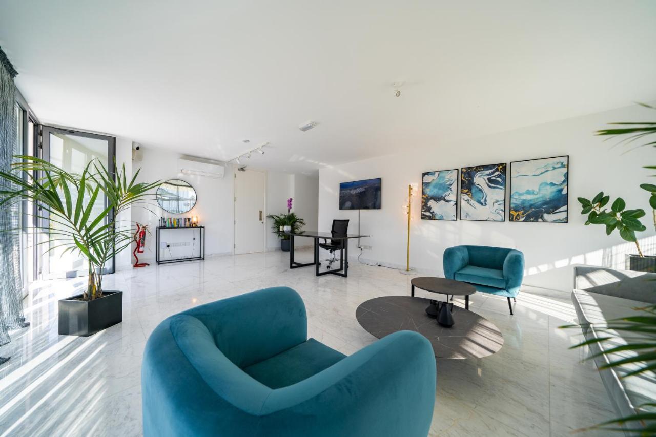 een woonkamer met een blauwe bank en stoelen bij Silver Park by Deserve in Paphos City