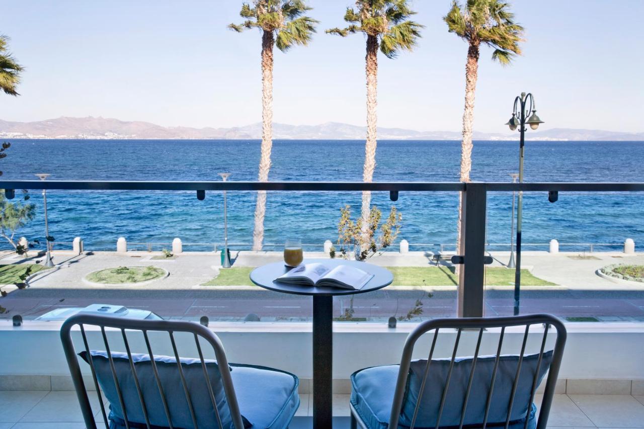 een uitzicht op de oceaan vanaf een balkon met palmbomen bij KoSea Boutique Hotel in Kos-stad