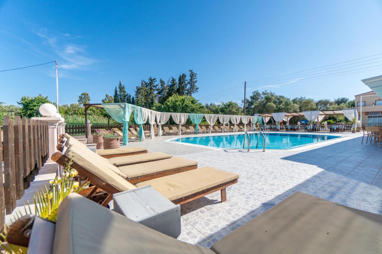 een zwembad met ligstoelen ernaast bij Saint Peter Bay Aparthotel in Kavos