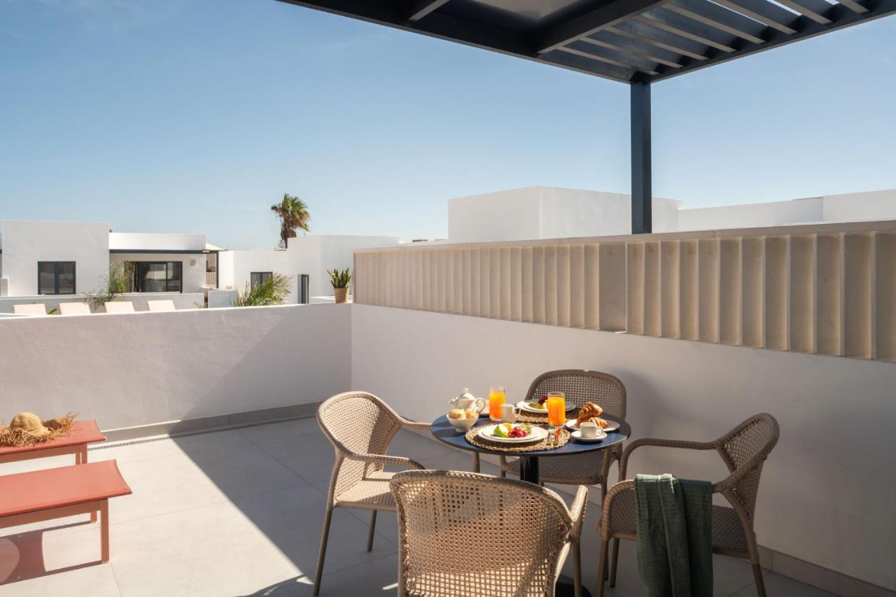 een terras met een tafel en stoelen op een dak bij Nazaret Beach - Adults only in Arrecife