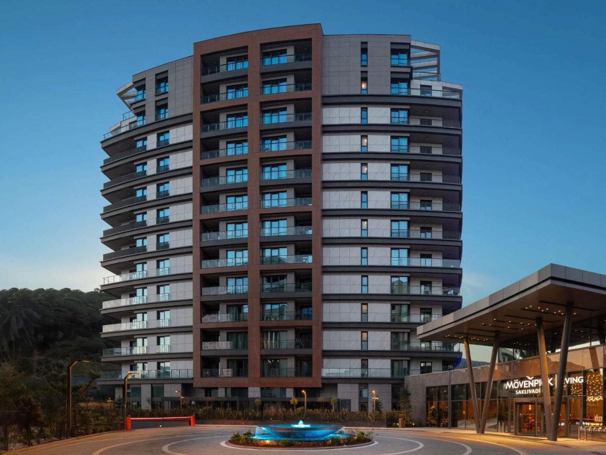 een hoog gebouw met een rotonde ervoor bij Mövenpick Living Istanbul Saklivadi in Istanbul