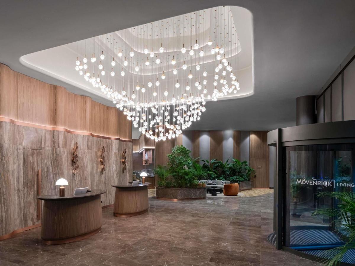 een lobby met een grote kroonluchter in een gebouw bij Mövenpick Living Istanbul Saklivadi in Istanbul