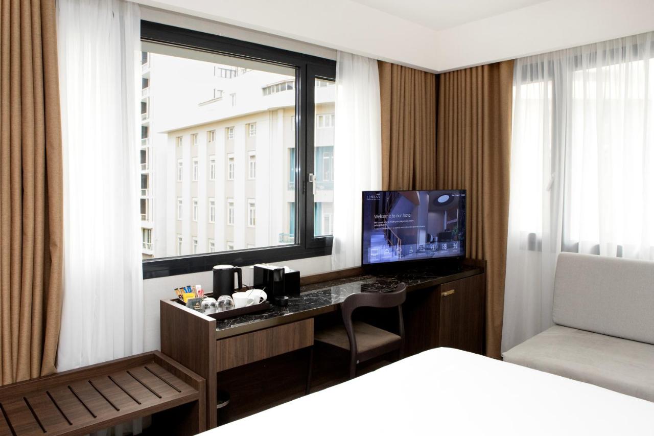een slaapkamer met een bureau met een tv en een raam bij Luwian Athens Boutique Hotel in Athene