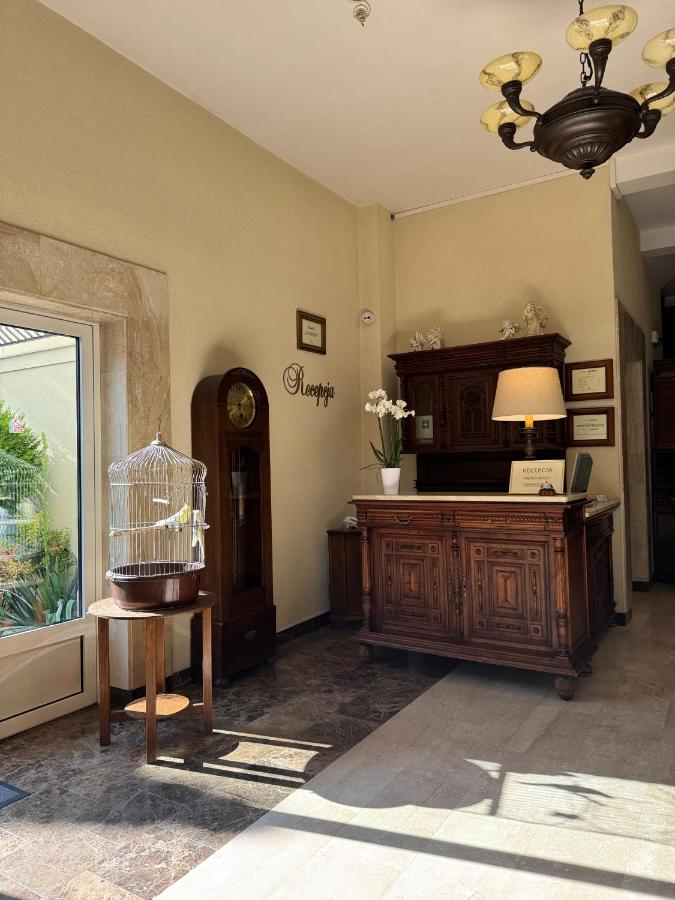 een kamer met een bureau, een klok en een raam bij Hotel Mateo in Stopnica