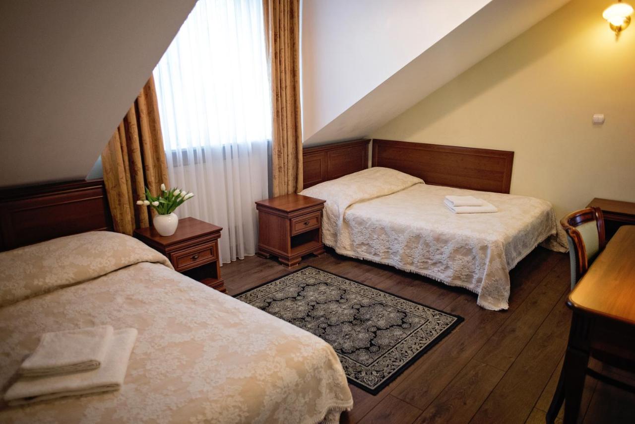 een hotelkamer met twee bedden en een raam bij Hotel Mateo in Stopnica