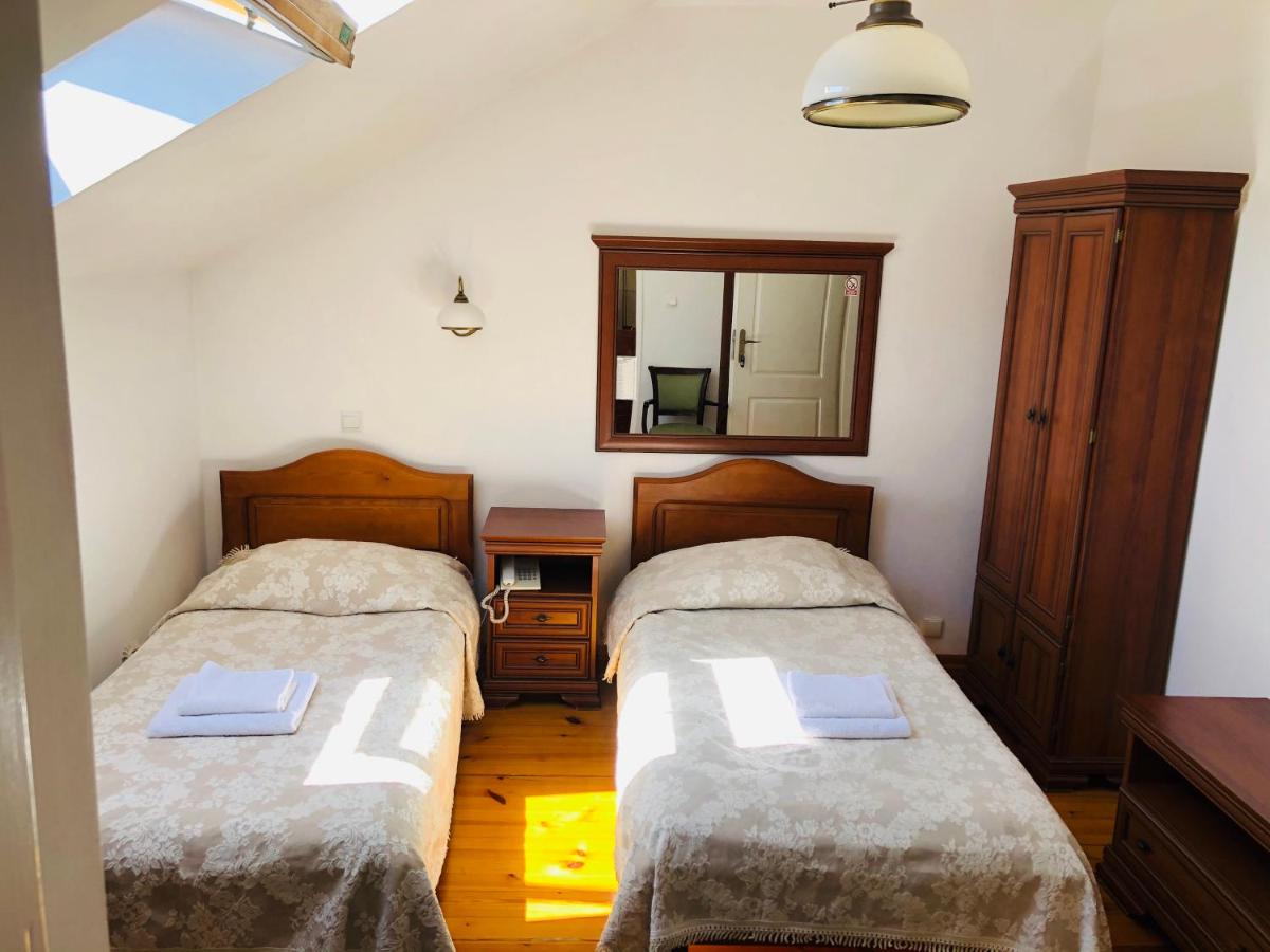 een slaapkamer met twee bedden en een spiegel bij Hotel Mateo in Stopnica