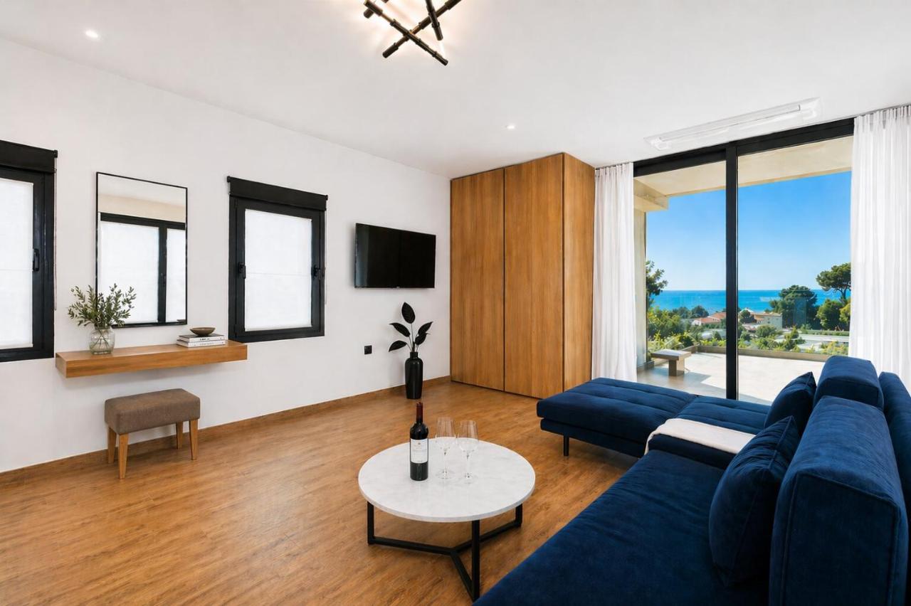 een woonkamer met een blauwe bank en een tafel bij Nobile Boutique Hotel in Agios Gordios