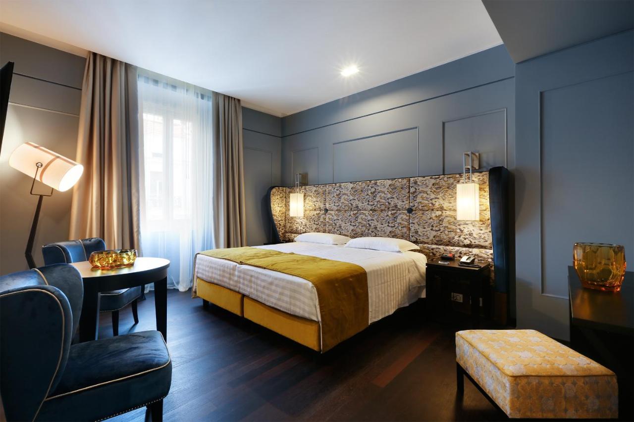 een hotelkamer met een bed en een stoel bij Stendhal Luxury Suites in Rome
