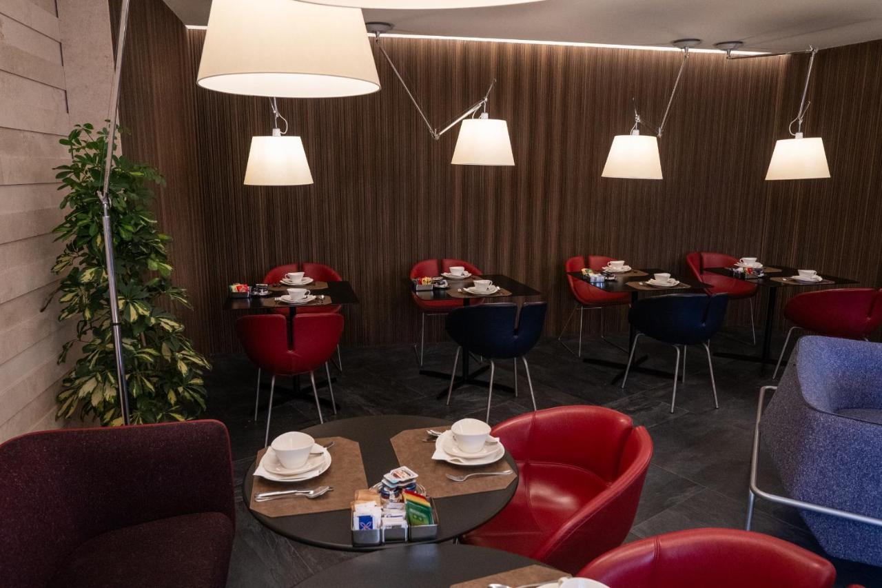 een restaurant met rode stoelen, tafels en lampen. bij Stendhal Luxury Suites in Rome