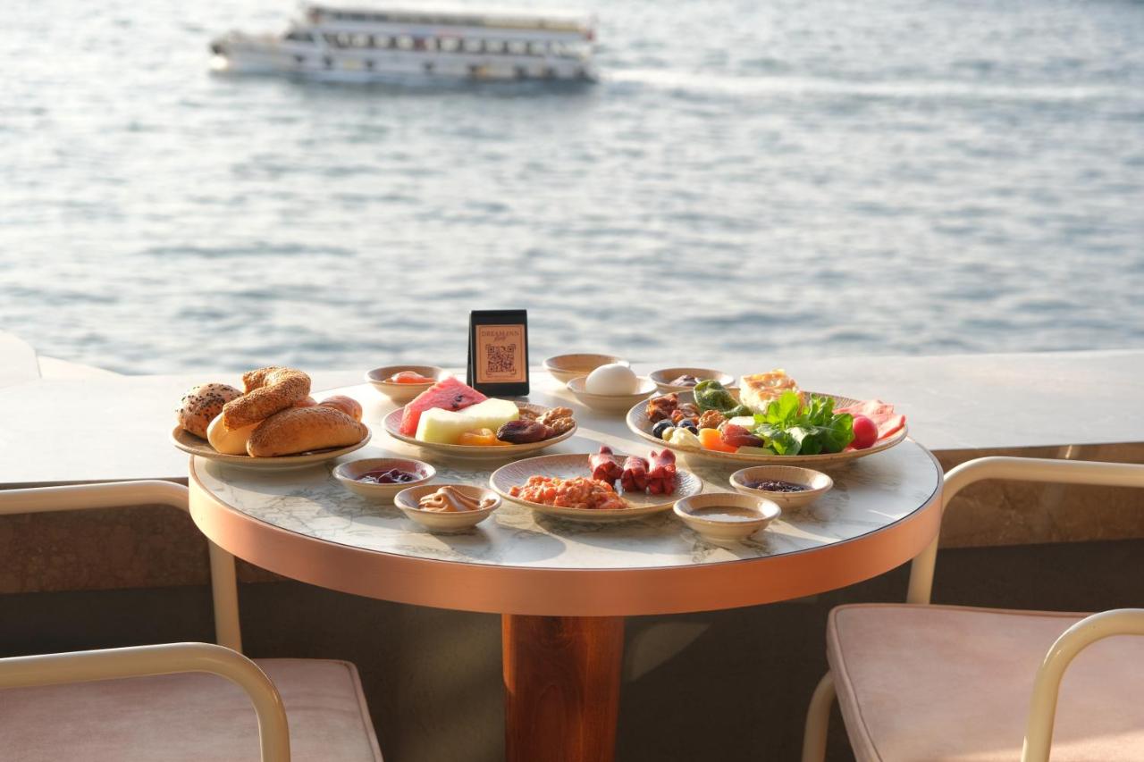 een tafel met een dienblad vol eten op een boot bij Dream Inn Karaköy Bosphorus in Istanbul