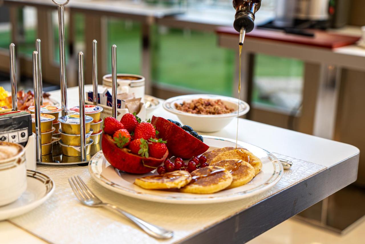 Een bord met aardbeien en pannenkoeken op tafel. bij Art Hotel Navigli in Milaan