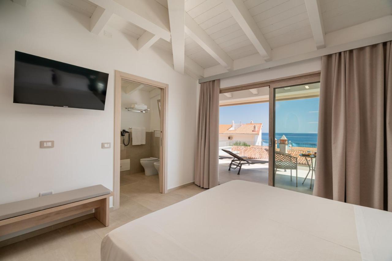 een slaapkamer met uitzicht op de oceaan bij Margaida Boutique Hotel & SPA in Cala Gonone