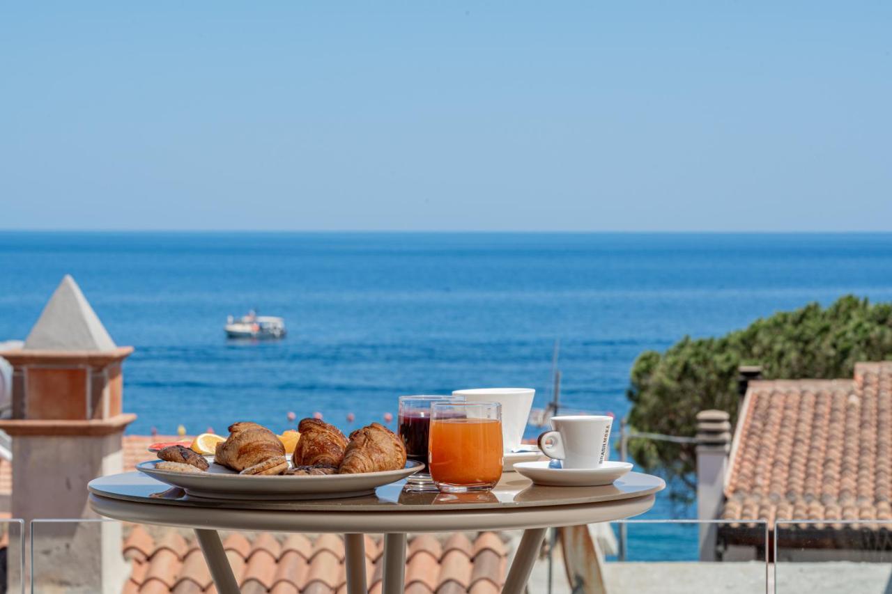 een tafel met een bord eten en drinken op een balkon bij Margaida Boutique Hotel & SPA in Cala Gonone