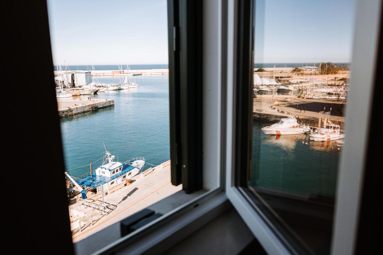 een raam met uitzicht op een haven met boten in het water bij Palazzo Giuditta in Monopoli