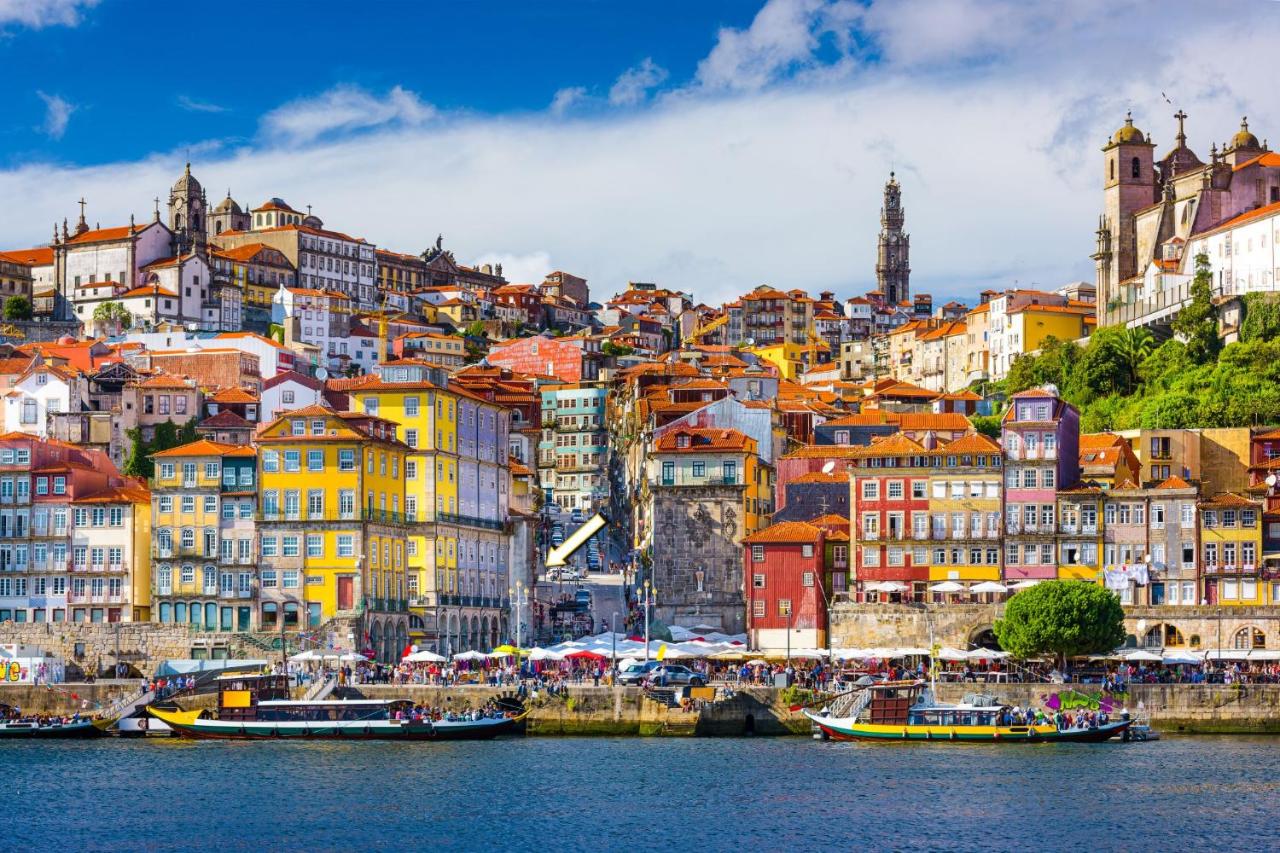 een stad met kleurrijke gebouwen en boten op het water bij Oca Ribeira do Porto AT in Porto