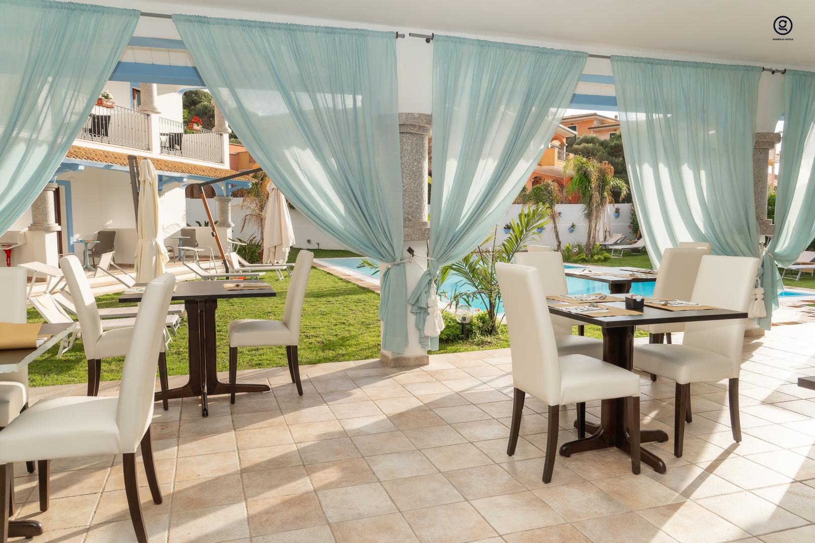 Buitenzwembad met ligbedden — GH Diana Hotel