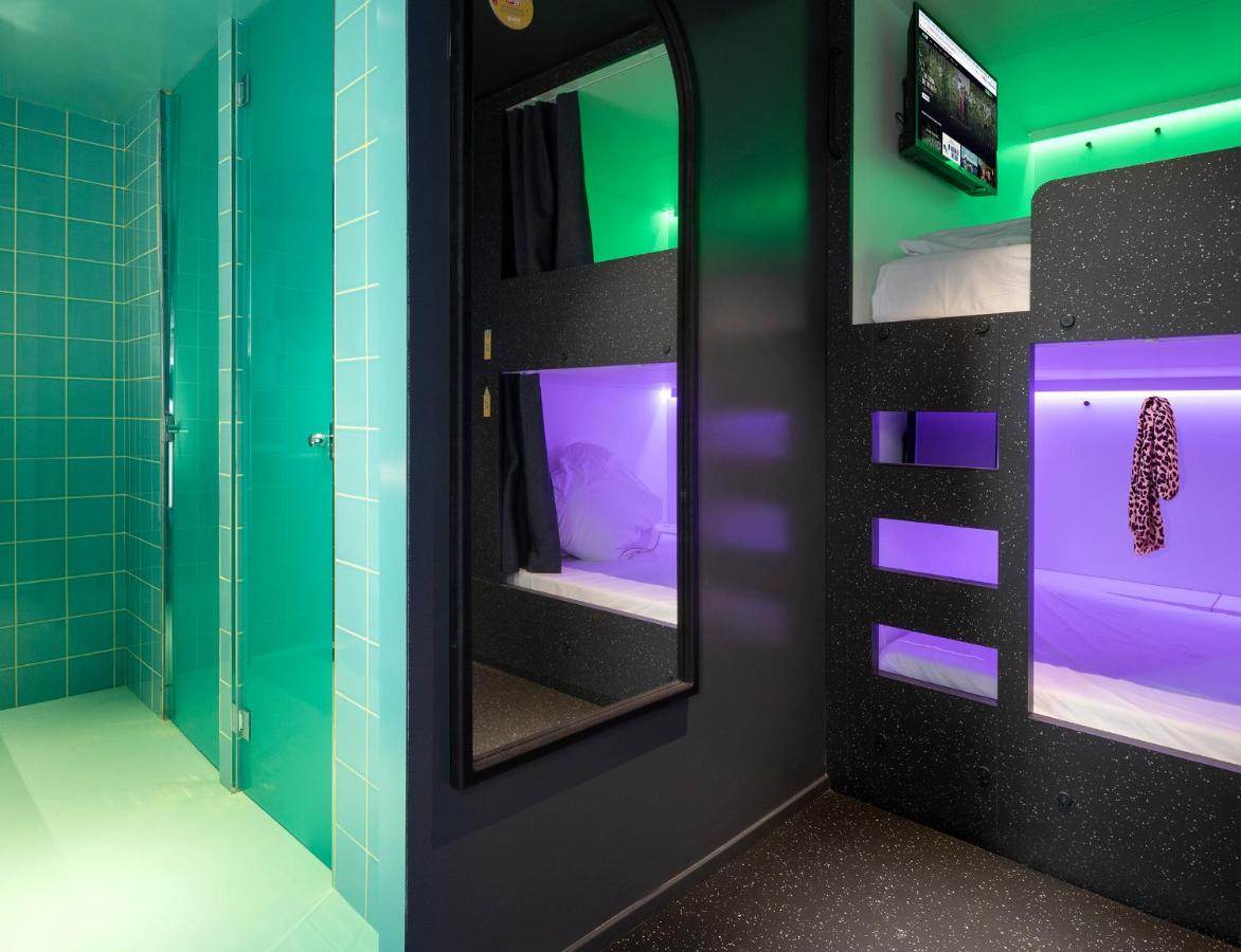 een badkamer met een spiegel en een tv erin bij AMISTAT City Hostel Barcelona in Barcelona