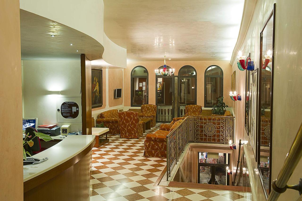 een woonkamer met een bank en een open haard bij Hotel Nazionale in Venetië