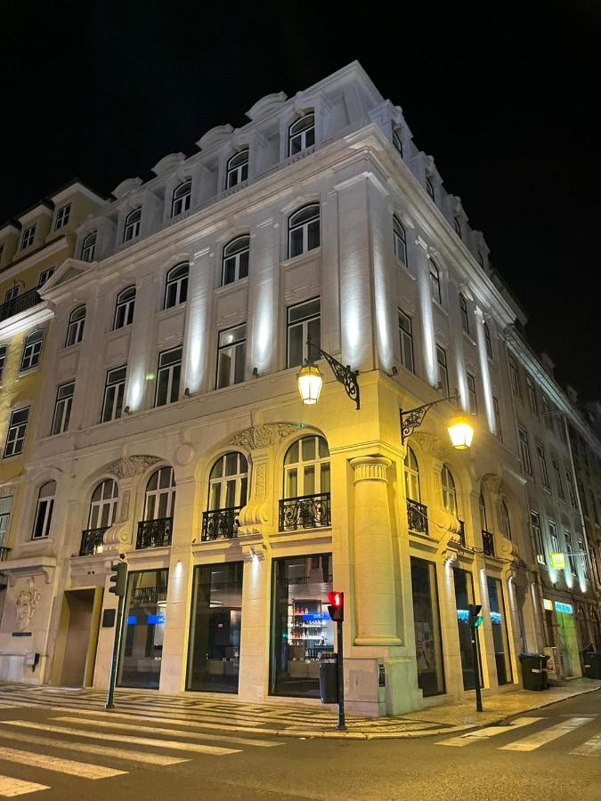 een groot wit gebouw in een stadsstraat 's nachts bij Golden Lisbon Hotel in Lissabon