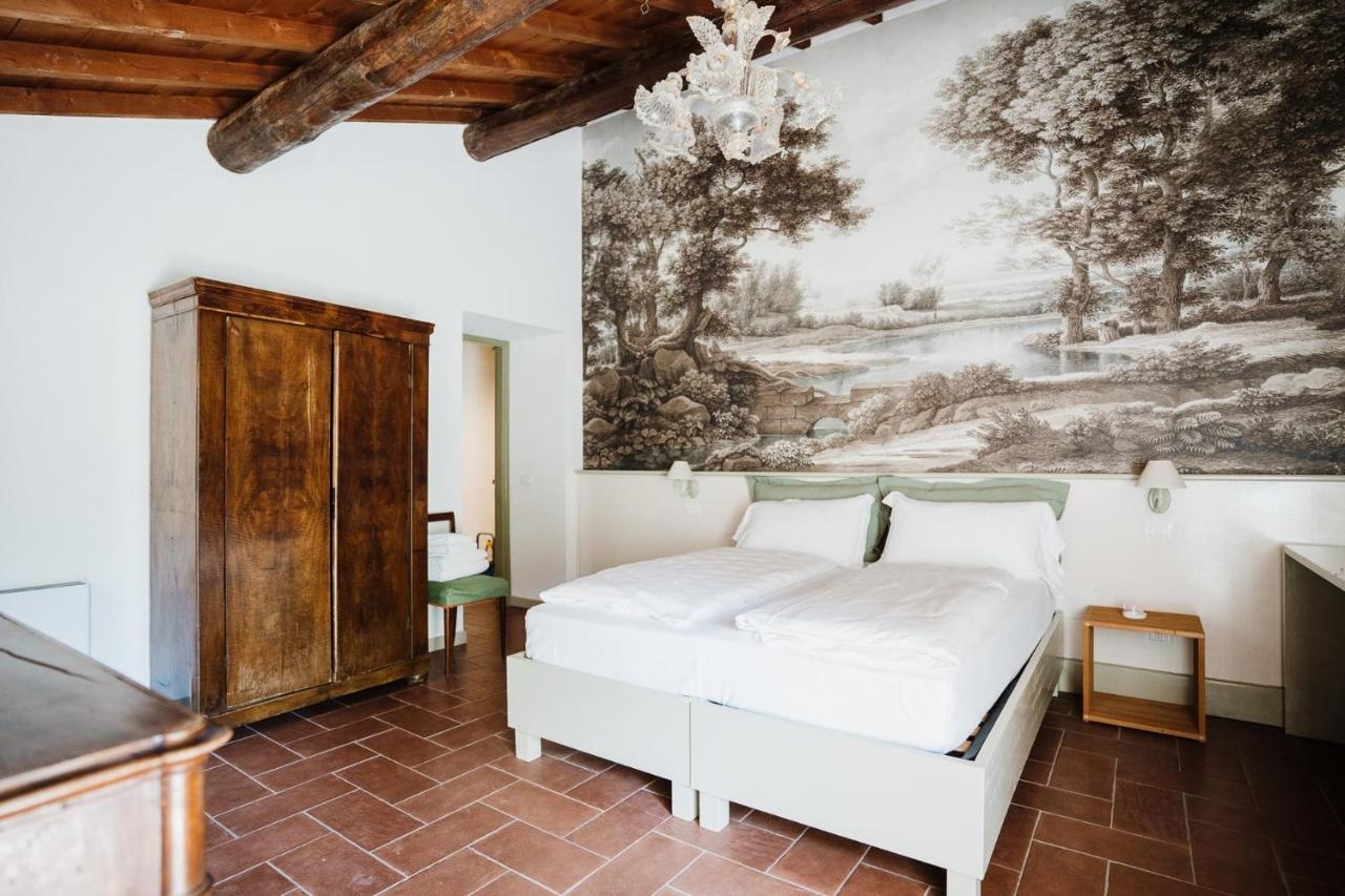 een slaapkamer met een bed en een schilderij aan de muur bij La Vineria di San Mattia in Verona