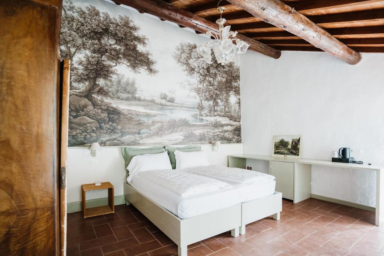 een slaapkamer met een bed en een schilderij aan de muur bij La Vineria di San Mattia in Verona